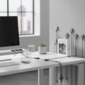 Magnetic cable clips organizing charging cables on a modern desk