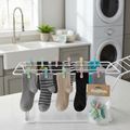 Small plastic clips keeping pairs of socks together on a drying rack in a laundry room