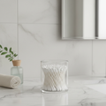 Clear container holding cotton swabs neatly on a bathroom counter